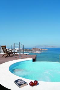 a swimming pool with a view of the ocean at Vrahos Boutique Hotel in Karavostasi
