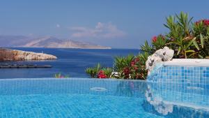 a swimming pool with a view of the ocean at Vrahos Boutique Hotel in Karavostasi