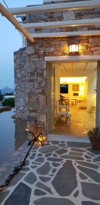 a stone house with a fireplace and a patio at Vrahos Boutique Hotel in Karavostasi
