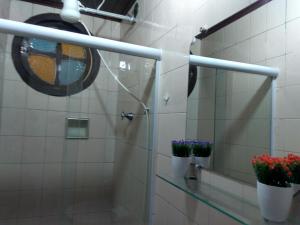 baño con 2 macetas en una estantería de cristal en Mineiro Suítes, en Arraial do Cabo
