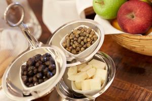 a table with three containers of food with nuts and fruit at Vrahos Boutique Hotel in Karavostasi
