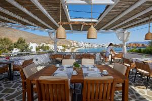 a restaurant with tables and chairs and a view of the ocean at Vrahos Boutique Hotel in Karavostasi