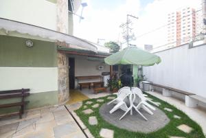 un patio con 2 sillas y una sombrilla en Flat Econômico, en São Paulo