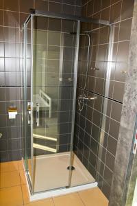 a shower with a glass door in a bathroom at Motel Lunar in Oświęcim