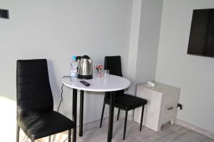 a table with two chairs and a tea kettle on it at Motel Lunar in Oświęcim