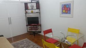 a dining room with a glass table and colorful chairs at Apartamento Praça do Lido in Rio de Janeiro