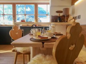 a kitchen with a table and chairs with food on it at Ciasa David Marebbe in San Vigilio Di Marebbe
