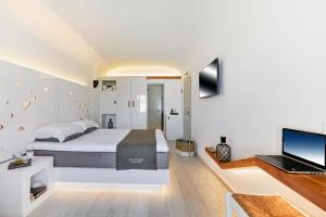 a bedroom with a bed and a desk with a laptop at Vrahos Boutique Hotel in Karavostasi