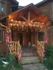 a wooden house with a porch with christmas lights at Inn on the Beartooth B&B in Red Lodge