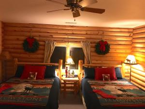 a bedroom with two beds in a log cabin at Inn on the Beartooth B&B in Red Lodge