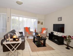 a living room with a couch and a tv at Libem Lodge 2 in Edenvale