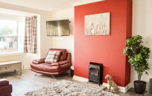 a living room with a chair and a fire place at The Darling Suites in Filey