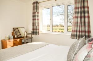 a bedroom with a bed and a window at The Darling Suites in Filey