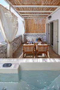 a villa with a pool and a table and chairs at Vrahos Boutique Hotel in Karavostasi