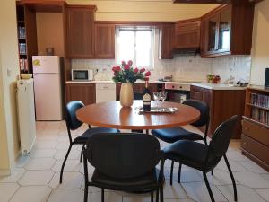 a kitchen with a table with chairs and a bottle of wine at ANNA'S SWEET HOME in Nea Makri