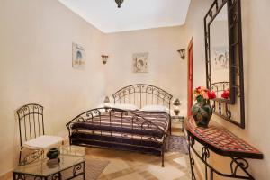 1 dormitorio con cama, espejo y mesa en Riad Julia en Marrakech