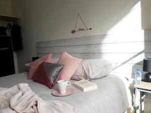 a bed with a book and a cup of coffee on it at le 104 - Disneyland Paris - in Magny-le-Hongre