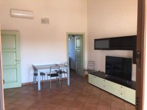 a living room with a table and a tv at Appartamento a Pula Vicino al Mare in Pula