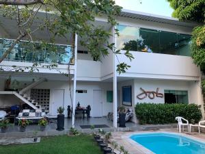 una casa con piscina frente a ella en Pousada Flat Hotel em Casa Forte, en Recife