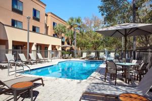 una piscina en un hotel con sillas y sombrilla en Courtyard by Marriott St. Augustine I-95, en St. Augustine
