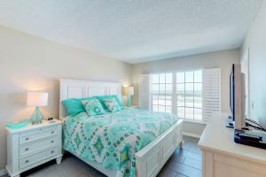 a bedroom with a bed and a desk and a television at Point East in New Smyrna Beach