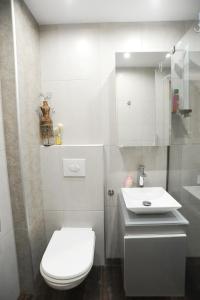 a white bathroom with a toilet and a sink at Thalia Premium Apartment in Kavála +14 photos