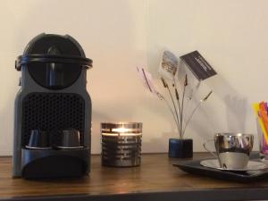 a coffee maker sitting on a wooden table with a plate at Studio cosy centre historique Saint-Michel in Bordeaux