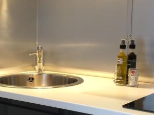 a kitchen counter with a sink and two bottles at Studio cosy centre historique Saint-Michel in Bordeaux +24 photos