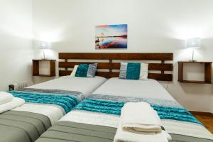two beds sitting next to each other in a bedroom at Casa Piscinas Naturais in Ribeira Grande