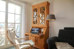 ein Wohnzimmer mit einem Schreibtisch und einem Laptop darauf in der Unterkunft Ferienwohnung SÜN in Zingst