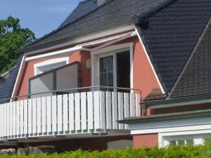 un balcón de una casa con una valla blanca en Ferienwohnung SÜN, en Zingst