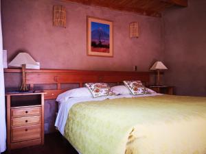 a bedroom with a large bed and two lamps on tables at Hostal Elim in San Pedro de Atacama