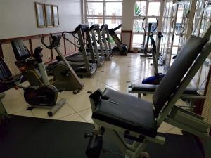 a gym with a bunch of treadms and machines at Tamareiras Park Hotel in Uberaba