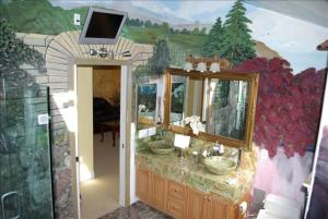 a bathroom with a sink and a tv on a wall at Luxury 5 Bedroom Home near SFO in San Bruno