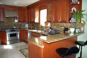 a kitchen with wooden cabinets and stainless steel appliances at Luxury 5 Bedroom Home near SFO in San Bruno