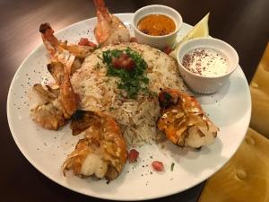 a plate of food with shrimp and rice on a table at Heathrow Inn Hotel in Hillingdon