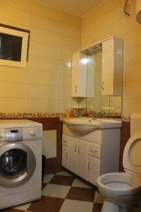 a bathroom with a washing machine and a sink at Hana Apartments Prishtina in Pristina +64 photos