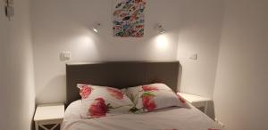 - une chambre avec un lit orné de fleurs roses dans l'établissement Cap Coz, à Fouesnant