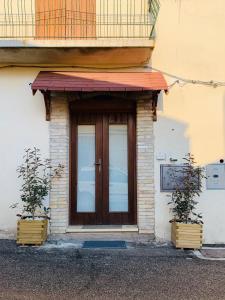 une porte d'entrée d'un immeuble avec deux plantes en pot dans l'établissement Casa Vacanze La Graziella - LA DÉPENDANCE, à Ferrandina