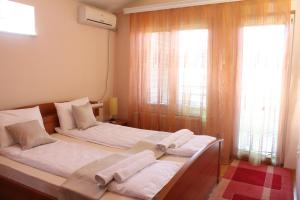A bed or beds in a room at Hana Apartments Prishtina