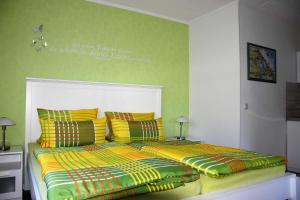 - une chambre dotée d'un lit avec des draps jaunes et verts dans l'établissement Traum_Fewo 2 Pers_, à Zinnowitz