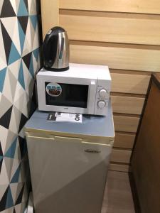 a microwave sitting on top of a refrigerator at SPABYELLEETLUI spa rouge ou bleu in Mouscron