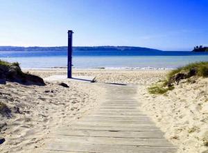 a wooden path on a sandy beach near the ocean at Housingcoruña Apartamento Playa Miño 03 in Miño