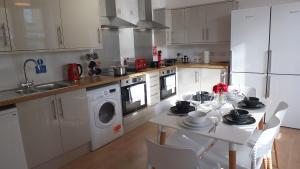 a kitchen with a table with chairs and a sink at The Mill Suites - Tas Accommodations in Cambridge