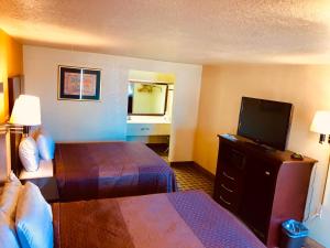 ein Hotelzimmer mit 2 Betten und einem Flachbild-TV in der Unterkunft Americas Best Value Inn and Suites Hope in Hope