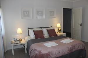 1 dormitorio con 1 cama grande, 2 mesas y 2 lámparas en Vigia's Guest House, en Viseu