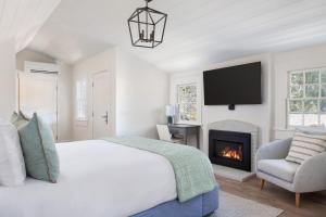 a white bedroom with a bed and a fireplace at Hideaway Santa Barbara, A Kirkwood Collection Hotel in Santa Barbara