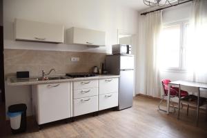 una cucina con armadietti bianchi e frigorifero bianco di Cozy 5 people Apartament a Mogliano Veneto