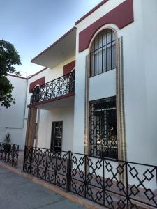 ein Haus mit einem Tor und einem Balkon in der Unterkunft Hotel del Bosque in Torreón