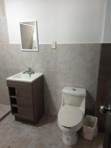 a bathroom with a toilet and a sink at Hotel del Bosque in Torreón